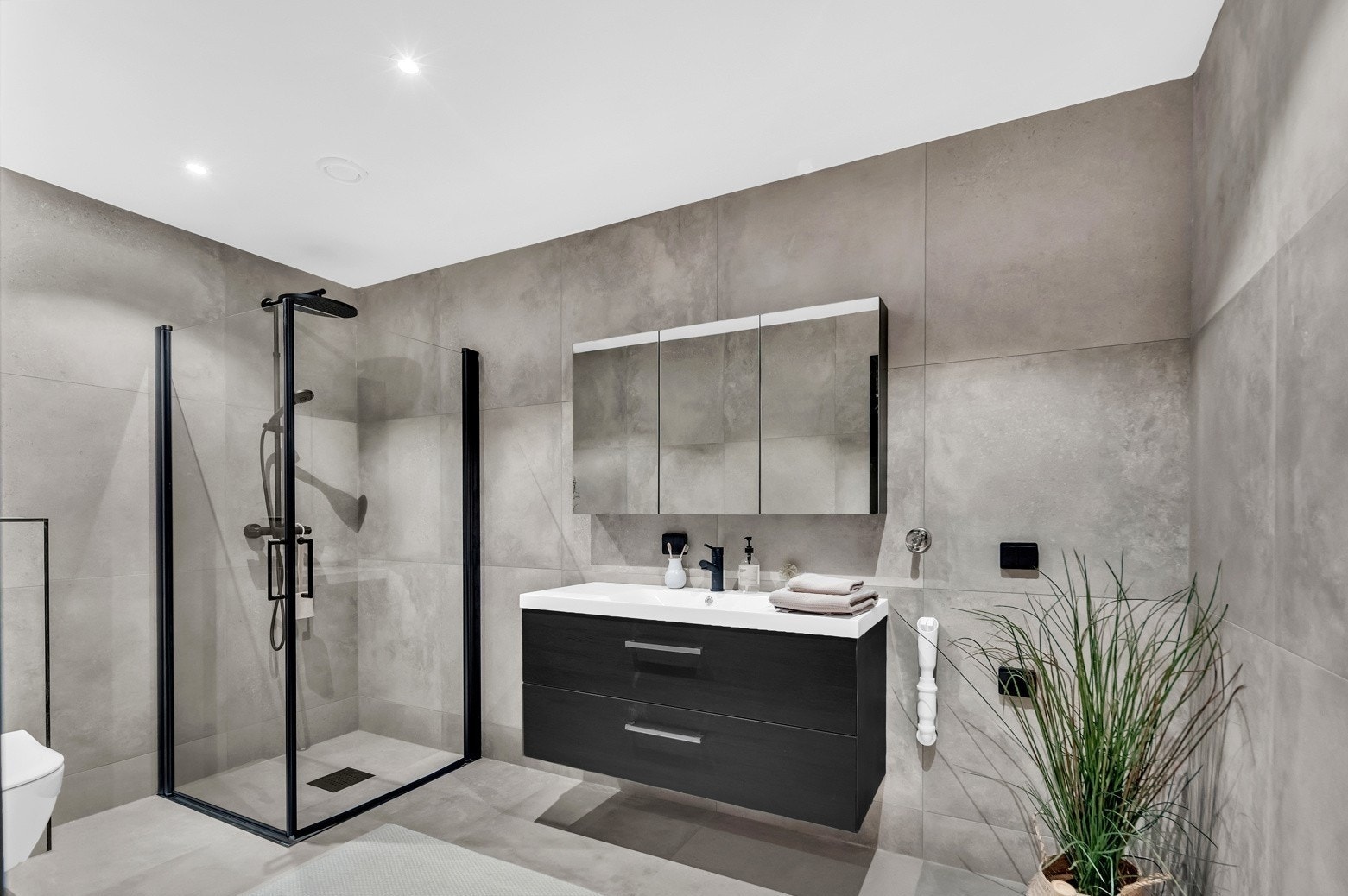 Badene er stilrene med store, delikate vegg- og gulvfliser i grått. Alle badene har downlights, gulvvarme og vegghengt toalett. Galleribilde