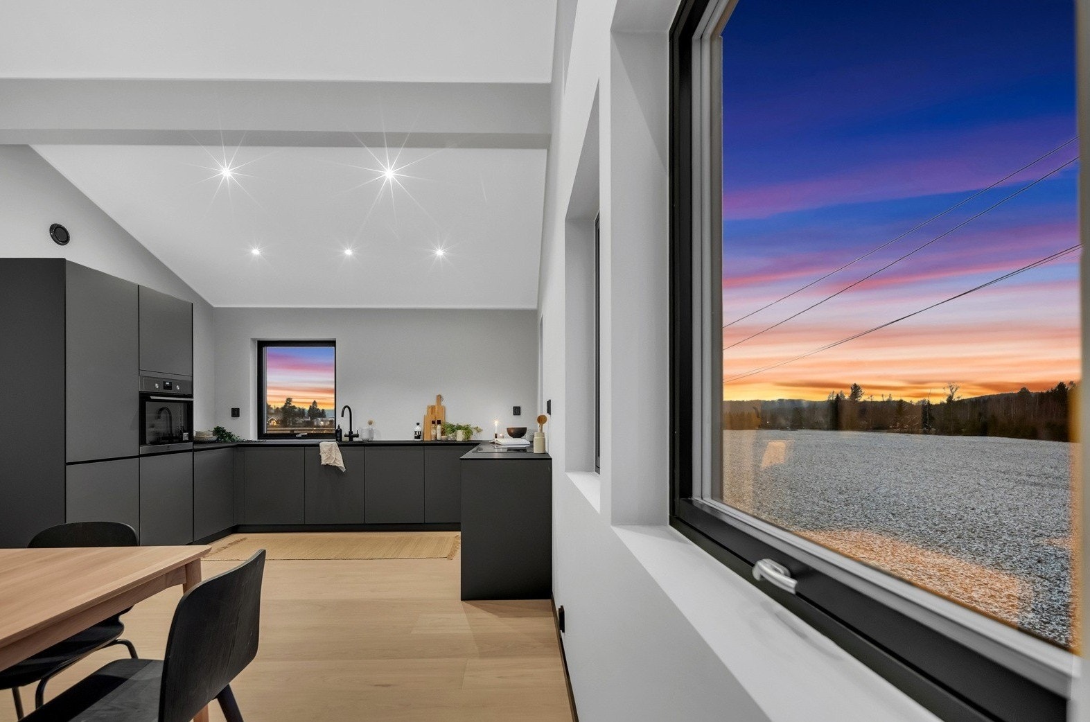 For et luftigere uttrykk er overskap droppet til fordel for vinduer og åpne flater, men det er likevel godt med både skap- og benkeplass på kjøkkenet. Galleribilde