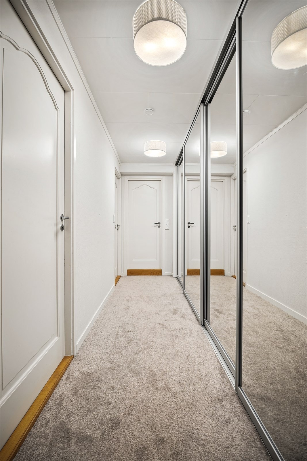 Gang med skyvedørsgarderobe som har speilfronter Galleribilde