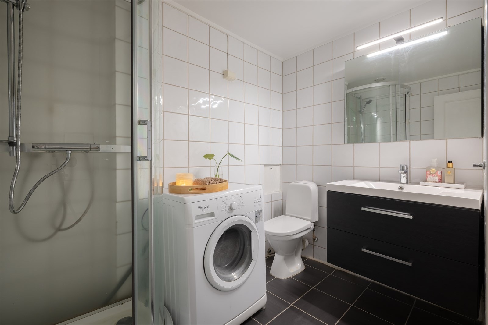 Badet fremstår som et praktisk og funksjonelt rom med flislagte overflater både på gulv og vegger. Galleribilde