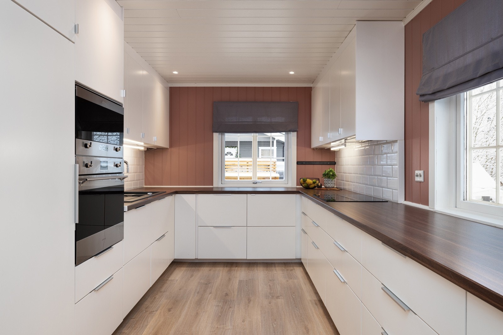 Moderne kjøkken med hvite fronter, god benkplass og innfelt belysning. Galleribilde