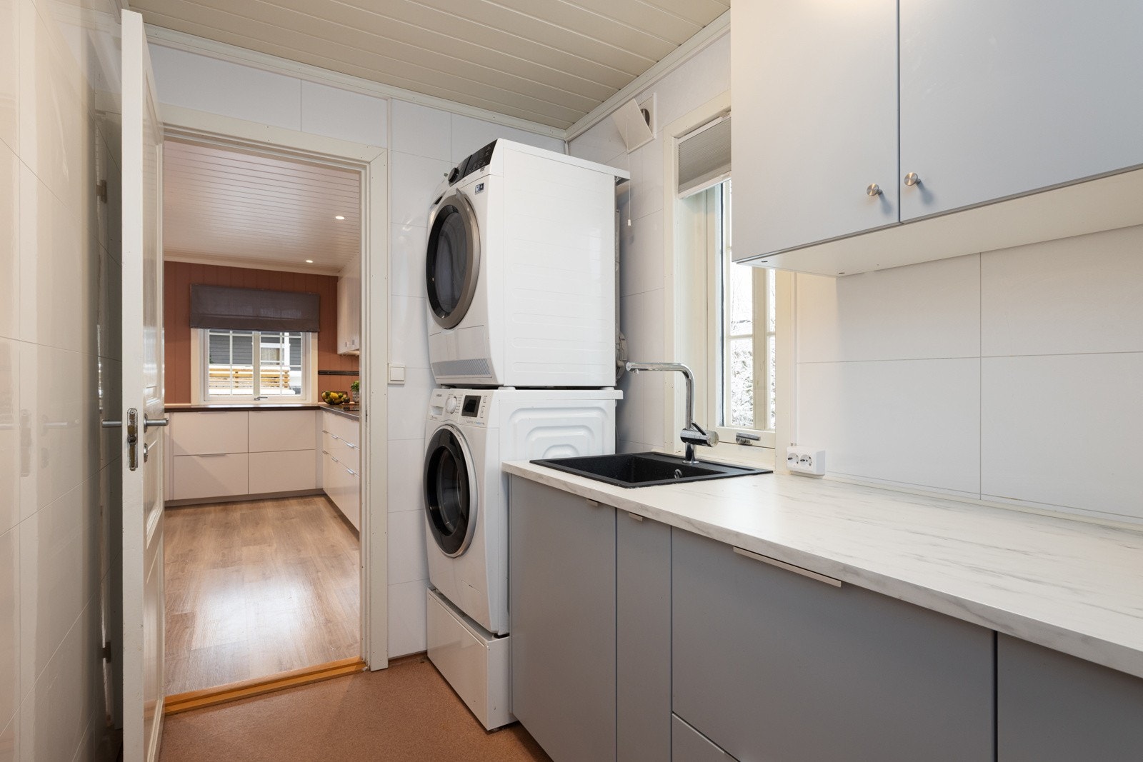 Praktisk vaskerom med god skapplass, arbeidsbenk og plassbesparende vask/tørk-tårn. Galleribilde