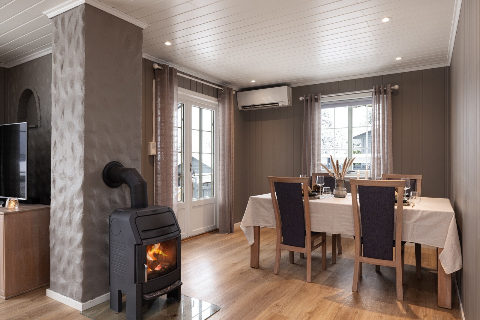 Lys og hyggelig spisestue med vedovn, store vnduer og integrerte downlights. Galleribilde