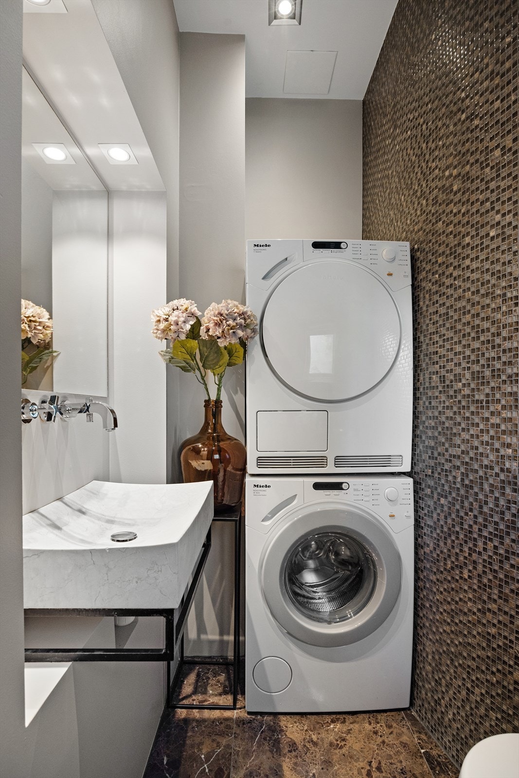 Her finner du opplegg for vaskemaskin, åpen dusj, veggmontert WC og servant med togreps blandebatteri. Galleribilde