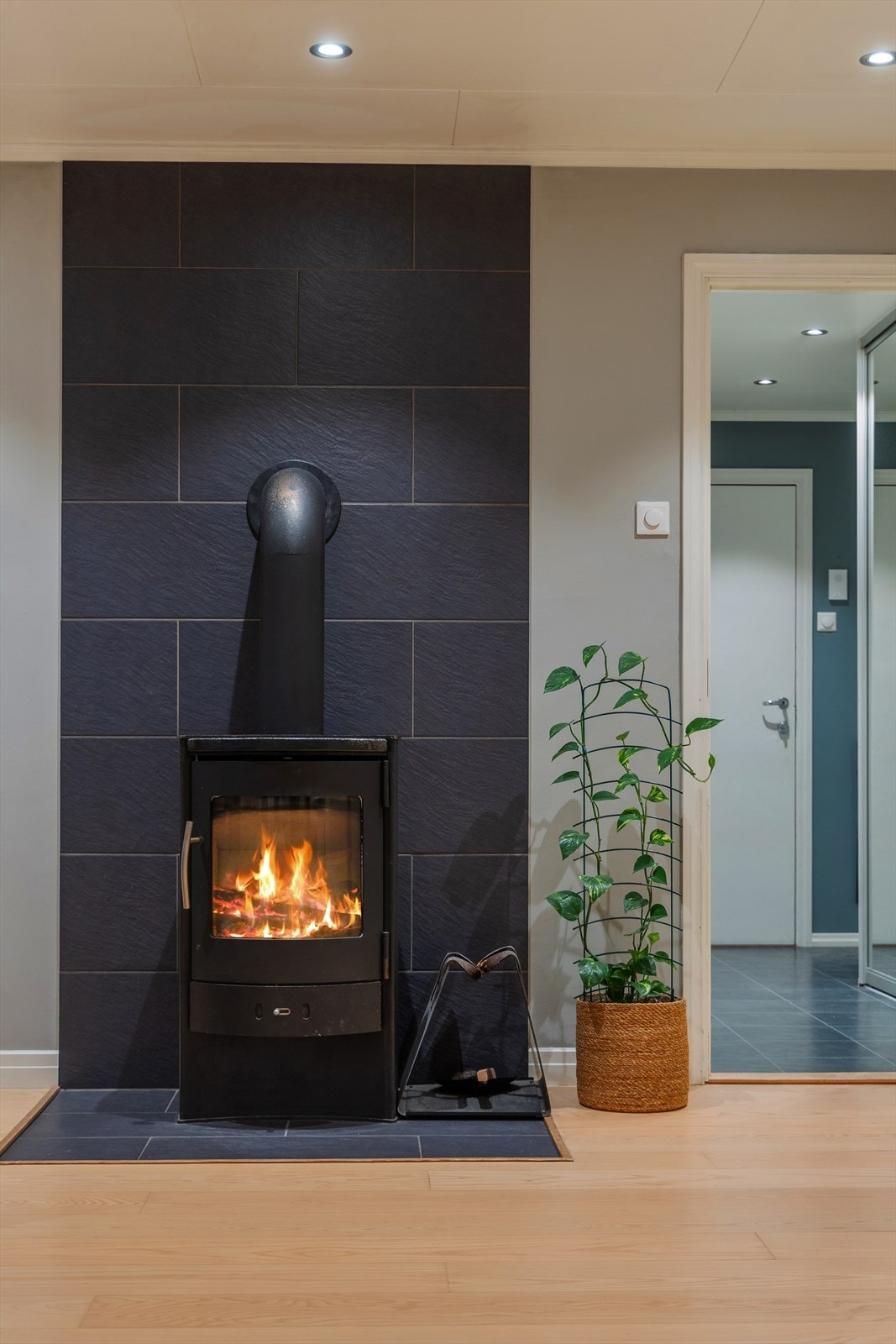 På stuen er det etablert lukket ilsted for lun og koselig oppvarming. Pipen er rehabilitert i regi av borettslaget i 2022. Galleribilde