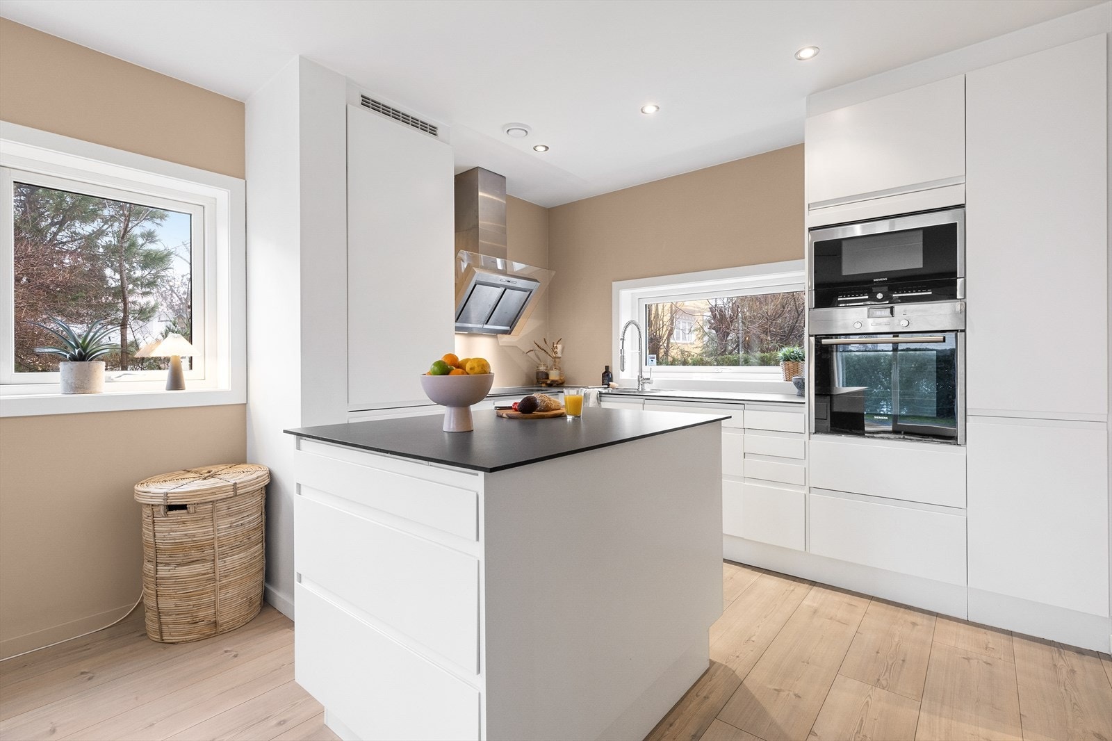 Tidløs og moderne kjøkkeninnredning fra Sigdal med slette fronter, kjøkkenøy og hvitevarer fra Siemens Galleribilde