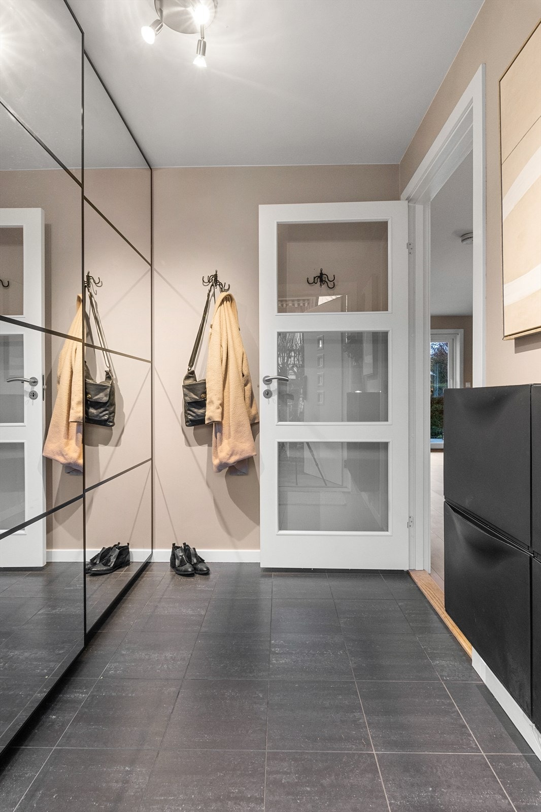 Entré i 1. etasje med flislagt gulv med varmekabler, malte veggflater og skyvedørsgarderobe med ny speildør i 2024 Galleribilde