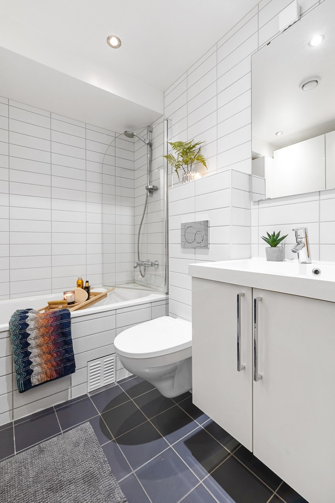 Helfliset bad/vaskerom i kjelleretasje med varmekabler i gulv og downlights i himling Galleribilde