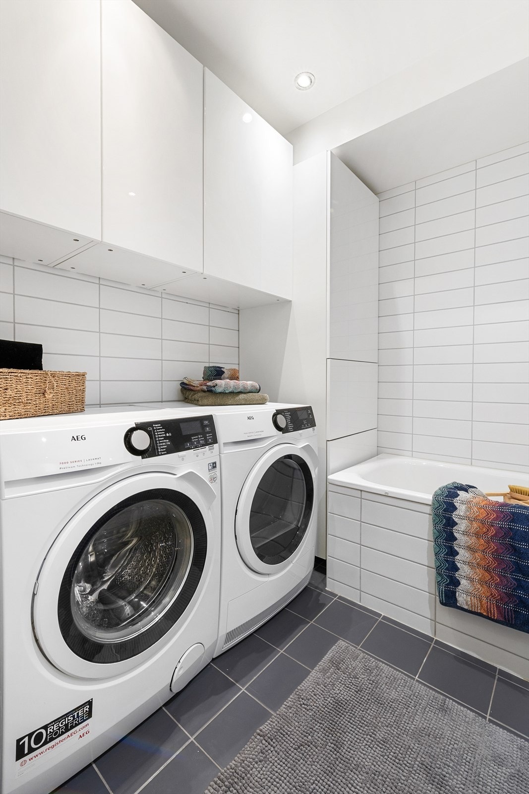 Opplegg og plass for vaskemaskin og tørketrommel, samt oppbevaringsmuligheter i vegg- og høyskap Galleribilde