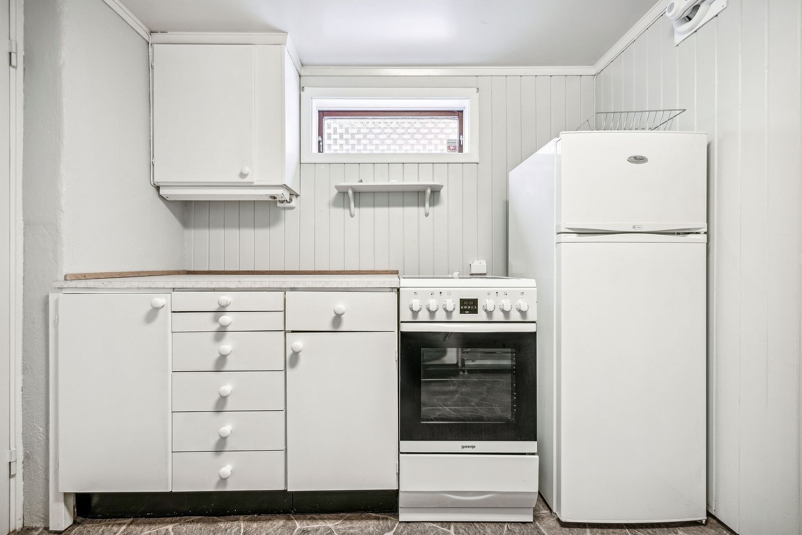 Kjøkken med komfyr, kombiskap og oppvaskmaskin. Galleribilde