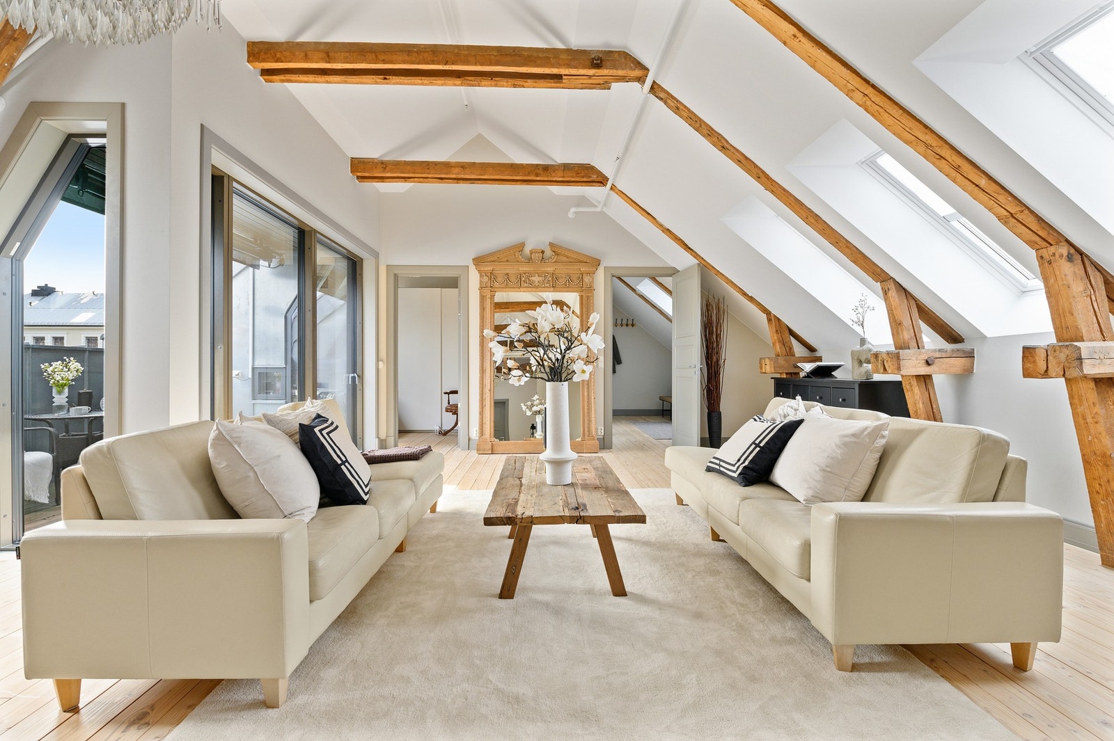 De eksponerte takbjelkene og peisovnen gir leiligheten en sjarmerende atmosfære. Galleribilde