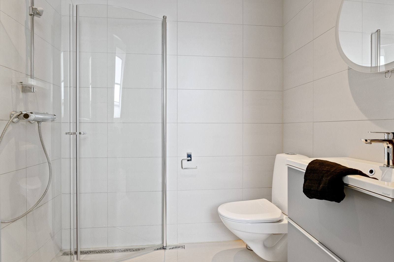 Leilighetens andre bad har flislagt gulv med vannbåren gulvvarme, flislagte veggoverflater og slettmalt tak. Galleribilde