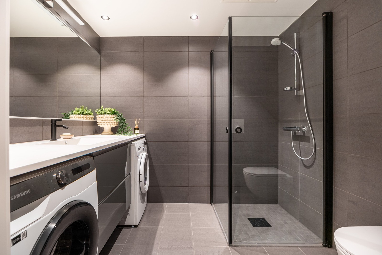 Delikat helfliset bad med vannbåren gulvvarme og himling med downlights. Galleribilde