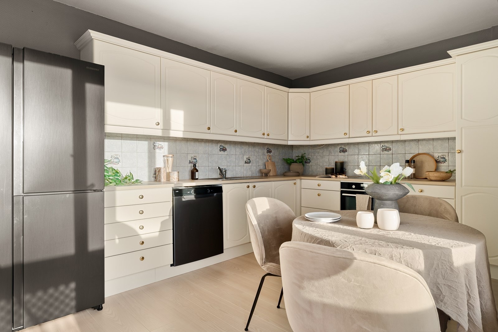 Et klassisk kjøkken med hvite profilerte fronter, godt med skap og skuffer og en solid, nyere benkeplate som gir gode arbeidsforhold. Galleribilde