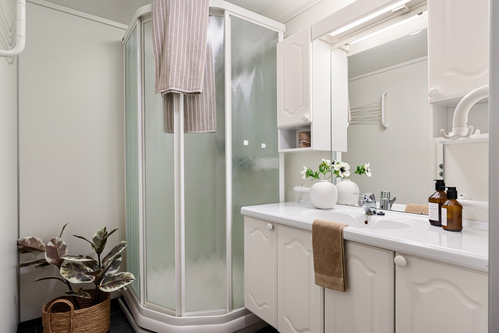 Badet er innredet med baderomsinnredning samt dusjkabinett Galleribilde