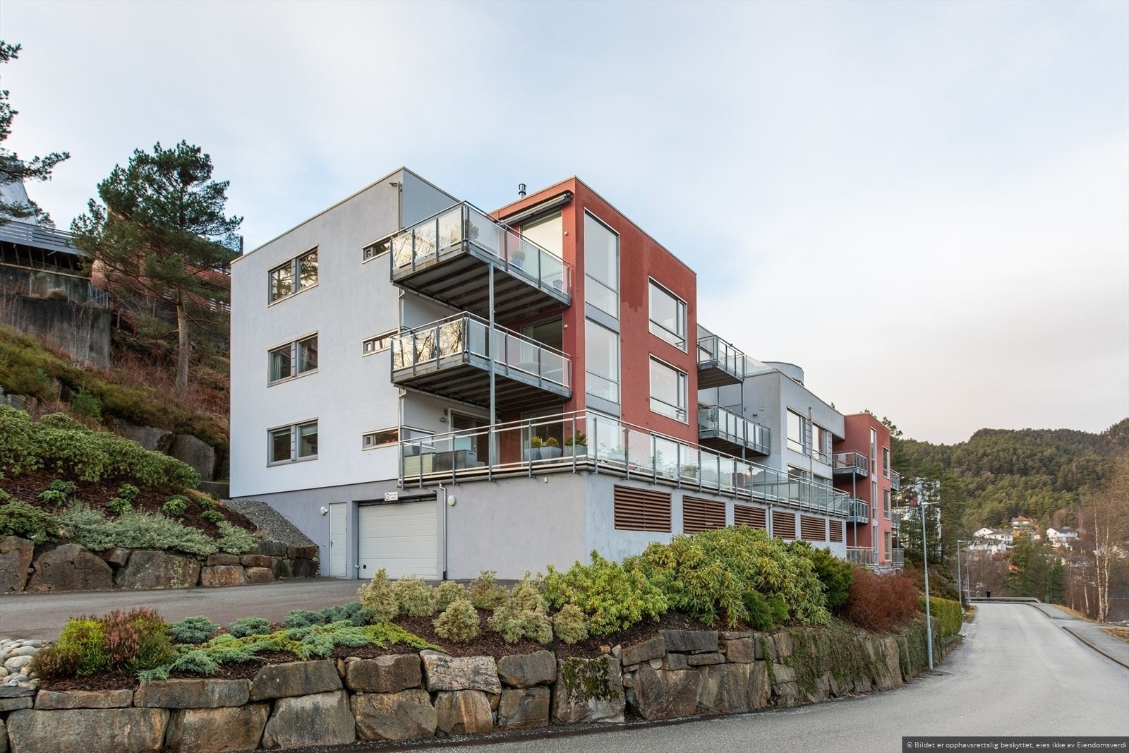 Tomten, som er pent opparbeidet med busker og diverse beplantning, samt parkeringsanlegg og gjesteparkeringsplasser som er felles for sameiet Galleribilde