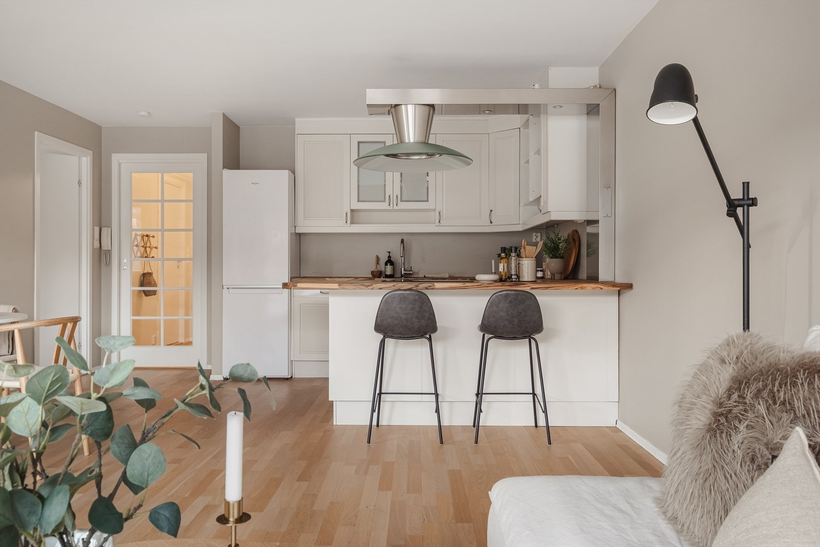 Leiligheten har en delikat løsning mellom stue og kjøkken, hvor kjøkkenet er praktisk utformet med godt av skap- og benkeplass. Galleribilde