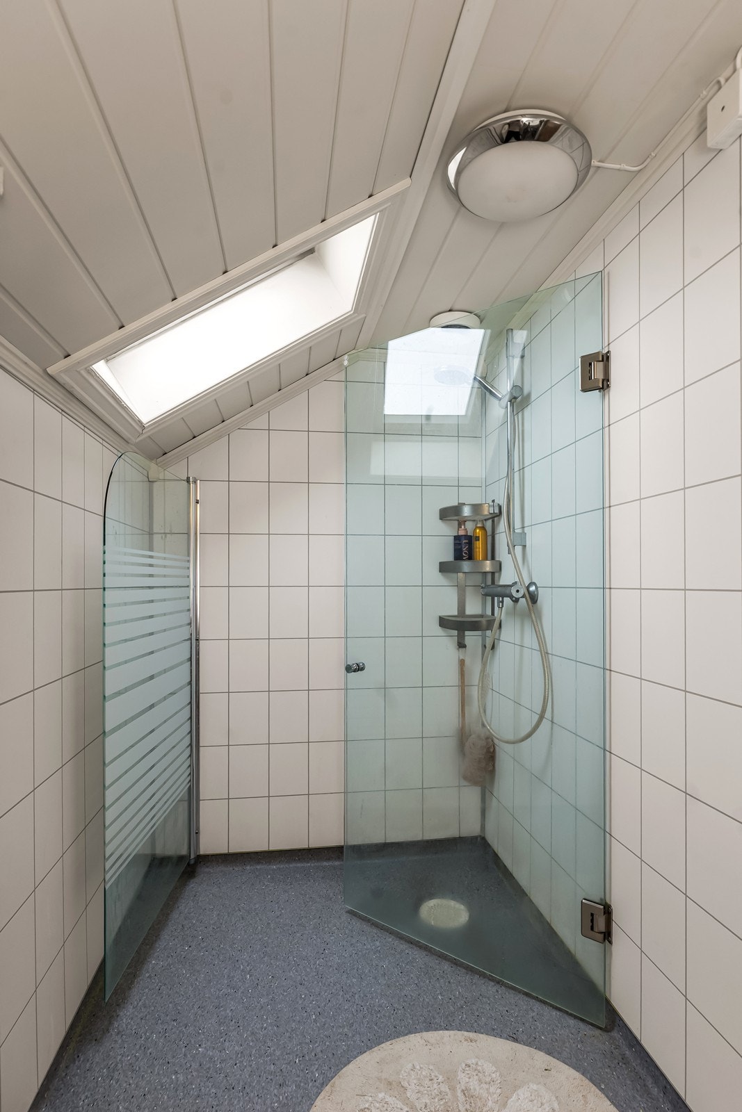 Badet i andre etasje, ble pusset opp i 2020. Det er belegg på gulvet og våtromsplater på veggene. Det er innredet med dusjhjørne med glassdører og et takvindu som gir dagslys. Galleribilde