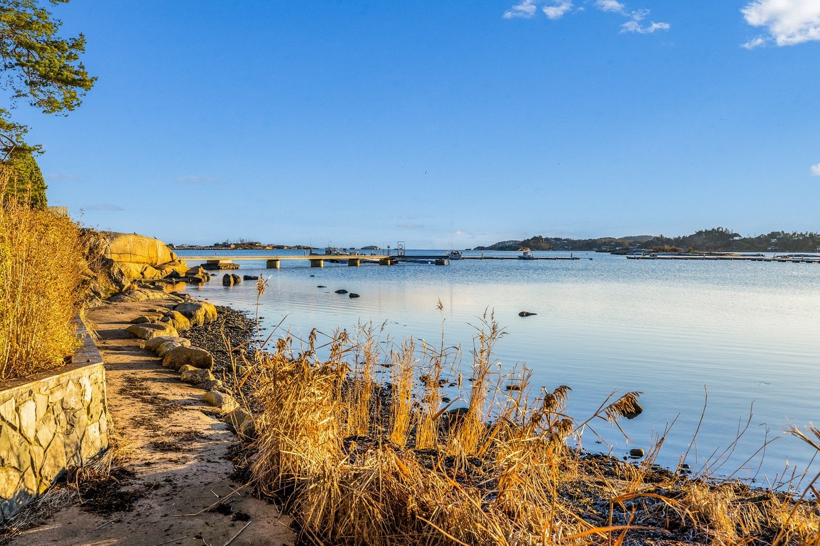 På inngangssiden har boligen en gårdsplass med blomsterbed og belegningsstein. Galleribilde