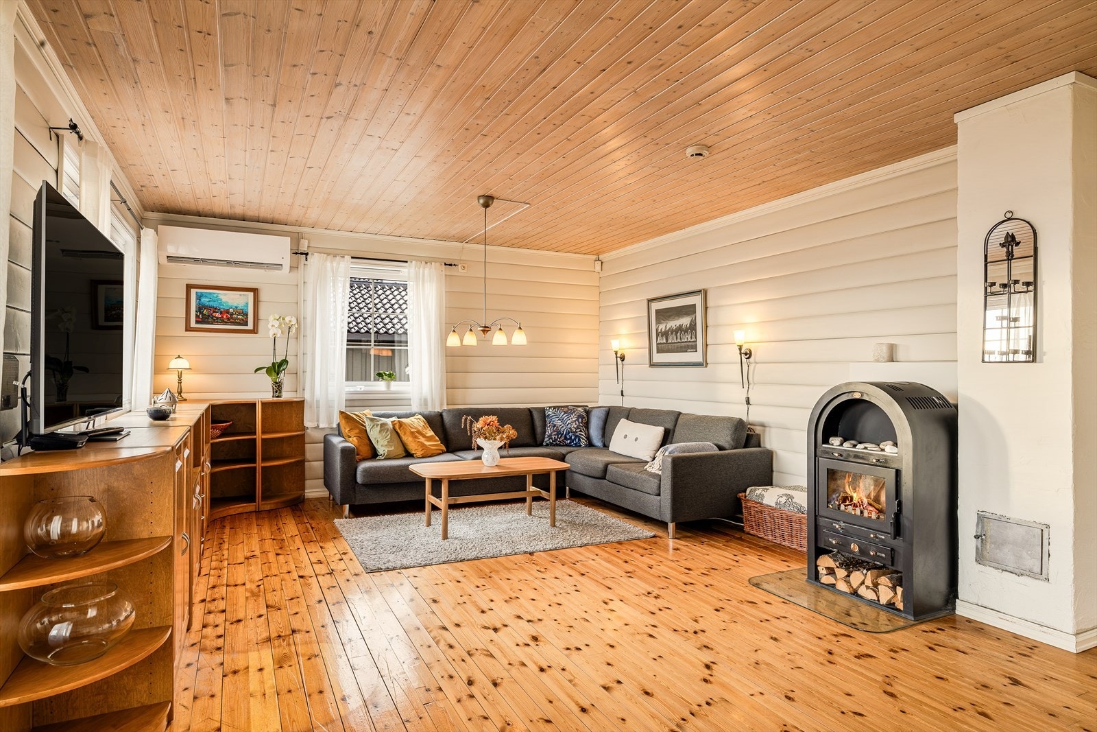 Med både peisovn og varmepumpe får man det lunt og godt i stuen. Galleribilde