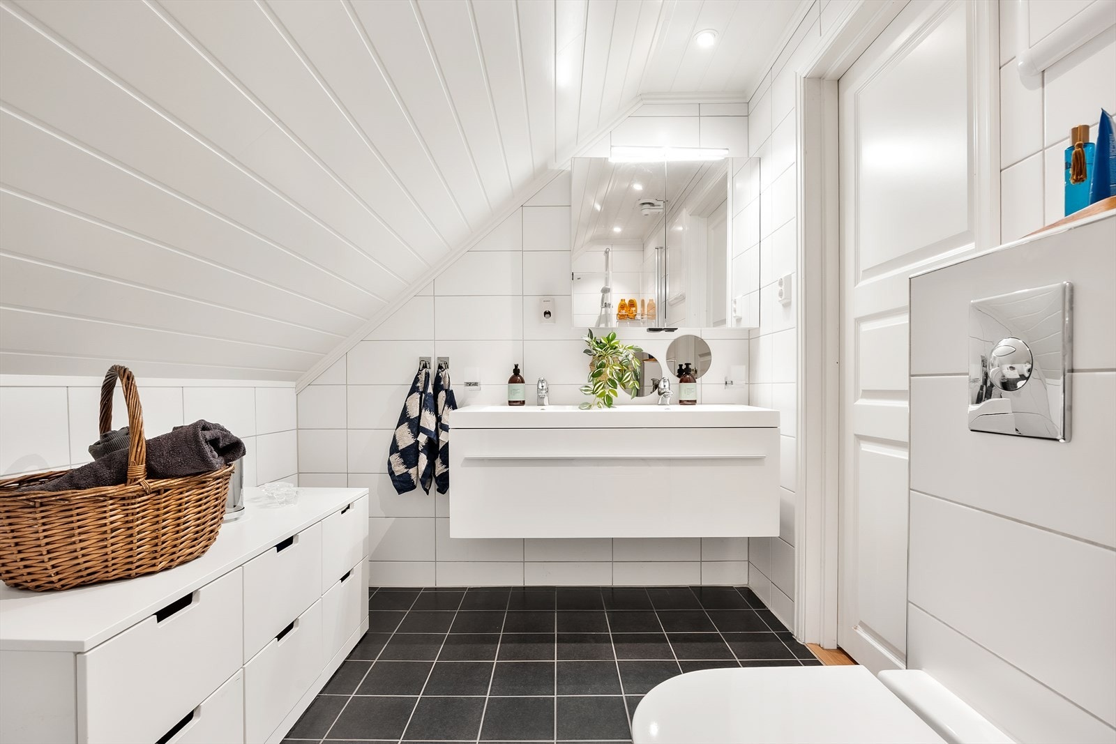 Baderomsinnredningen består av dusjhjørne, dobbeltservant, vaskemaskin og vegghengt toalett. Galleribilde