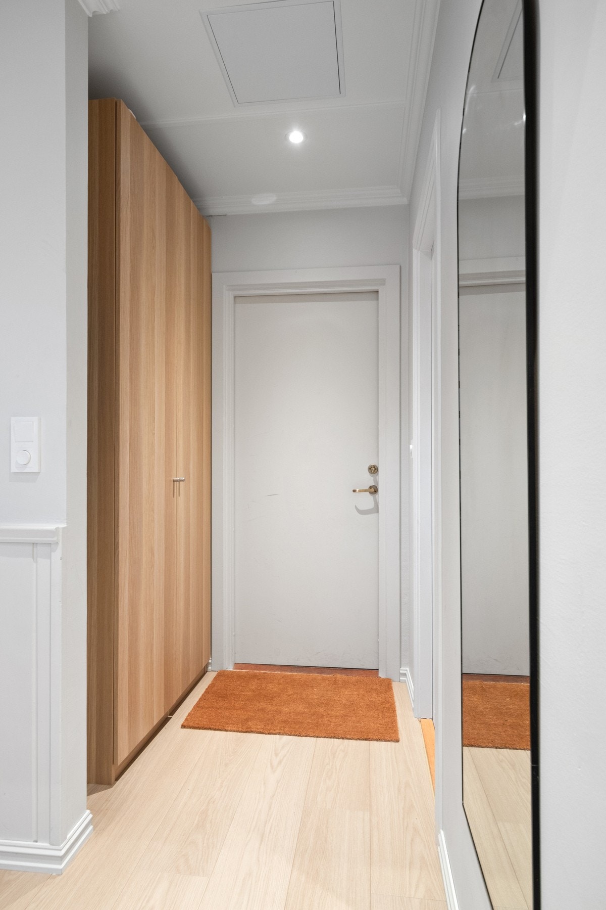 Vel inne har gangen downlights, 1-stavs laminatgulv og vegger malt i en dus gråtone Galleribilde