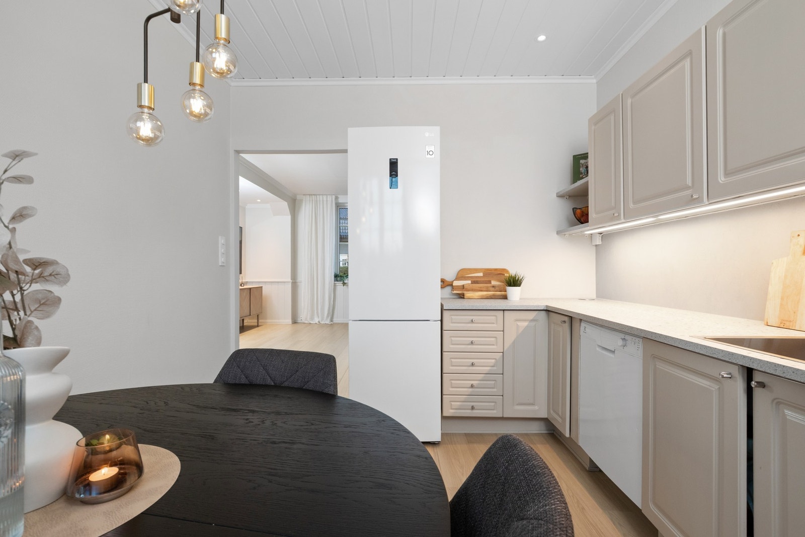 Belysning er montert over benken, og over kokesonen har kjøkkenet en ventilator med avtrekk ut Galleribilde