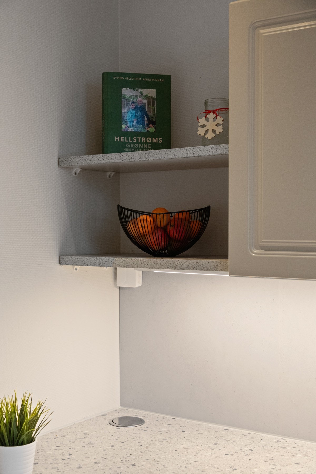 Downlights i taket tilfører ekstra lys til arbeidsflatene, og hvitevarene består av komfyr og oppvaskmaskin Galleribilde