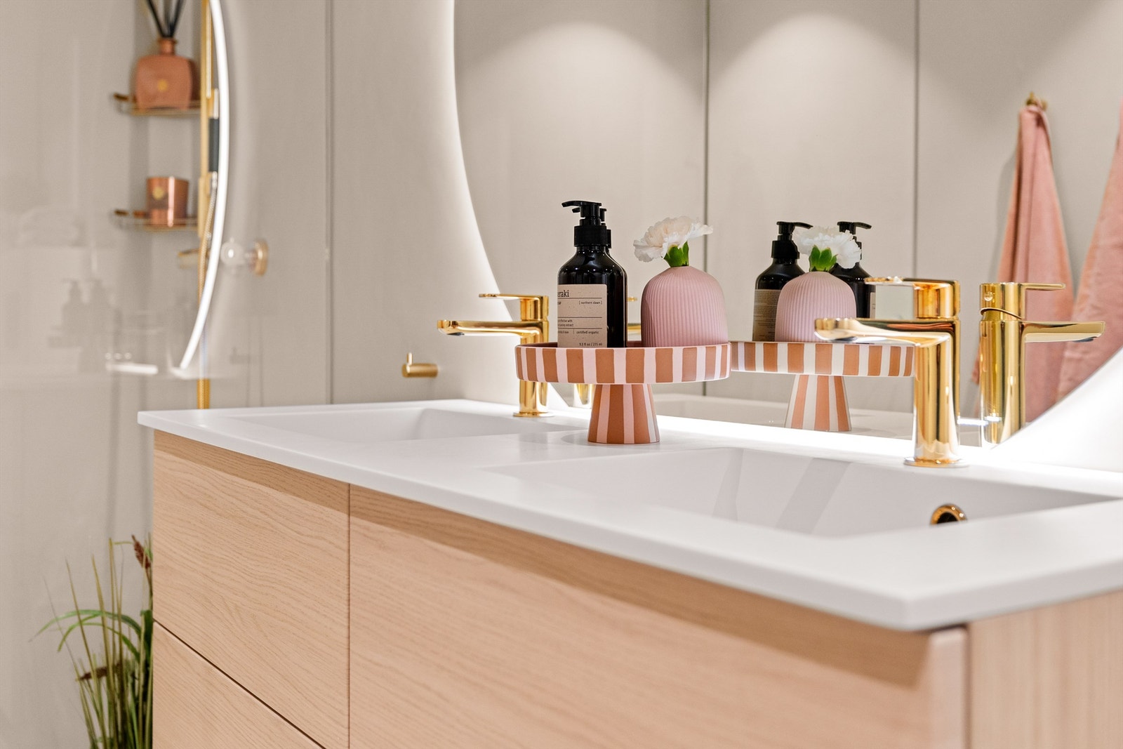 Detaljbilde av den doble servanten og de stilrene messingarmaturene. Galleribilde