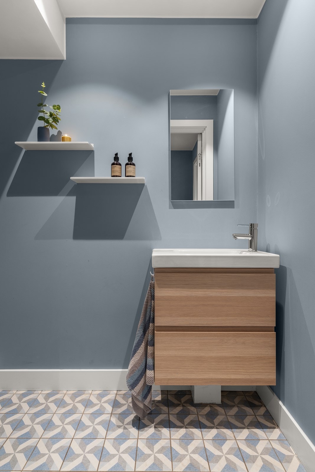 Rommet har en gjennomført stil med delikate fargevalg og mønstrede gulvfliser. Galleribilde