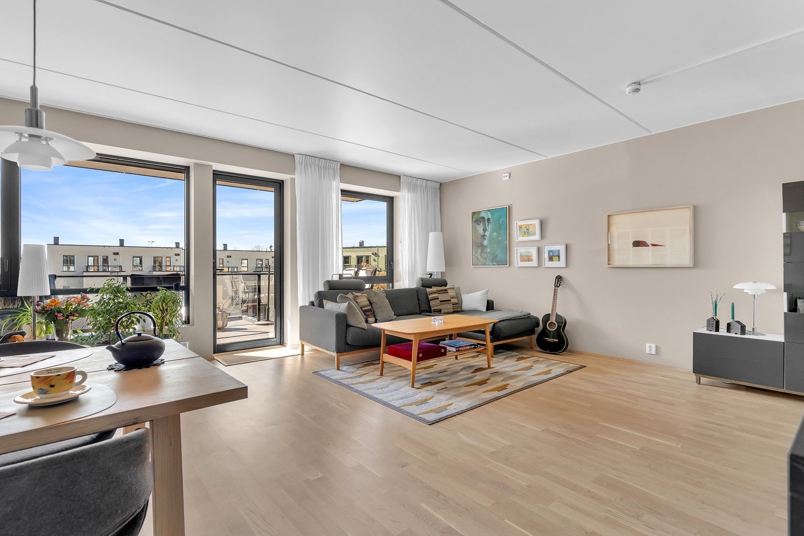 Leiligheten har en lys og luftig stue med store vindusflater som slipper inn rikelig med dagslys. Den åpne løsningen mot kjøkkenet gir en sosial atmosfære, perfekt for både hverdagsliv og hyggelige sammenkomster. Galleribilde