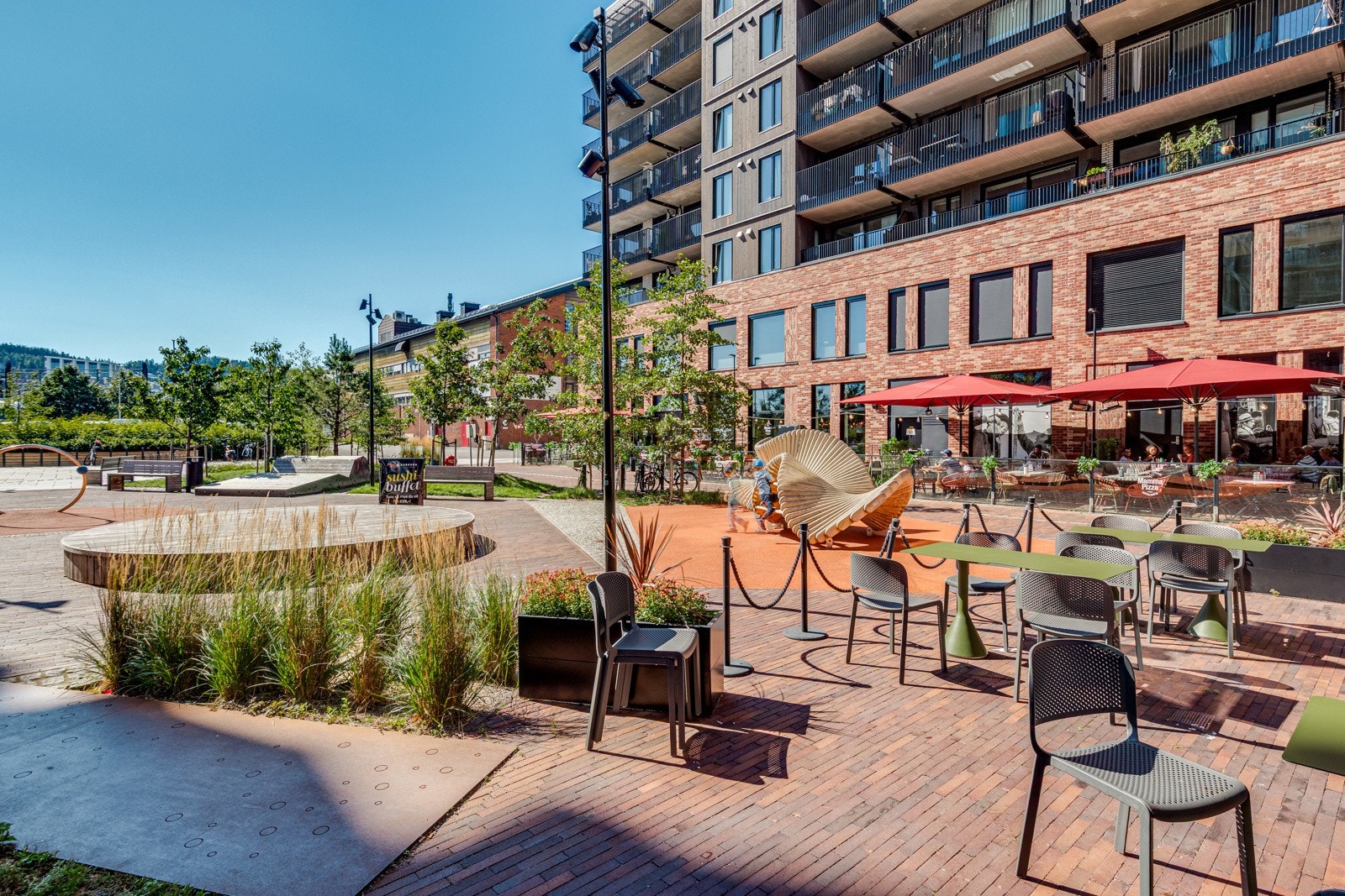 Treningsstativ og sittebenker i solrike omgivelser også på bakkeplan. Galleribilde