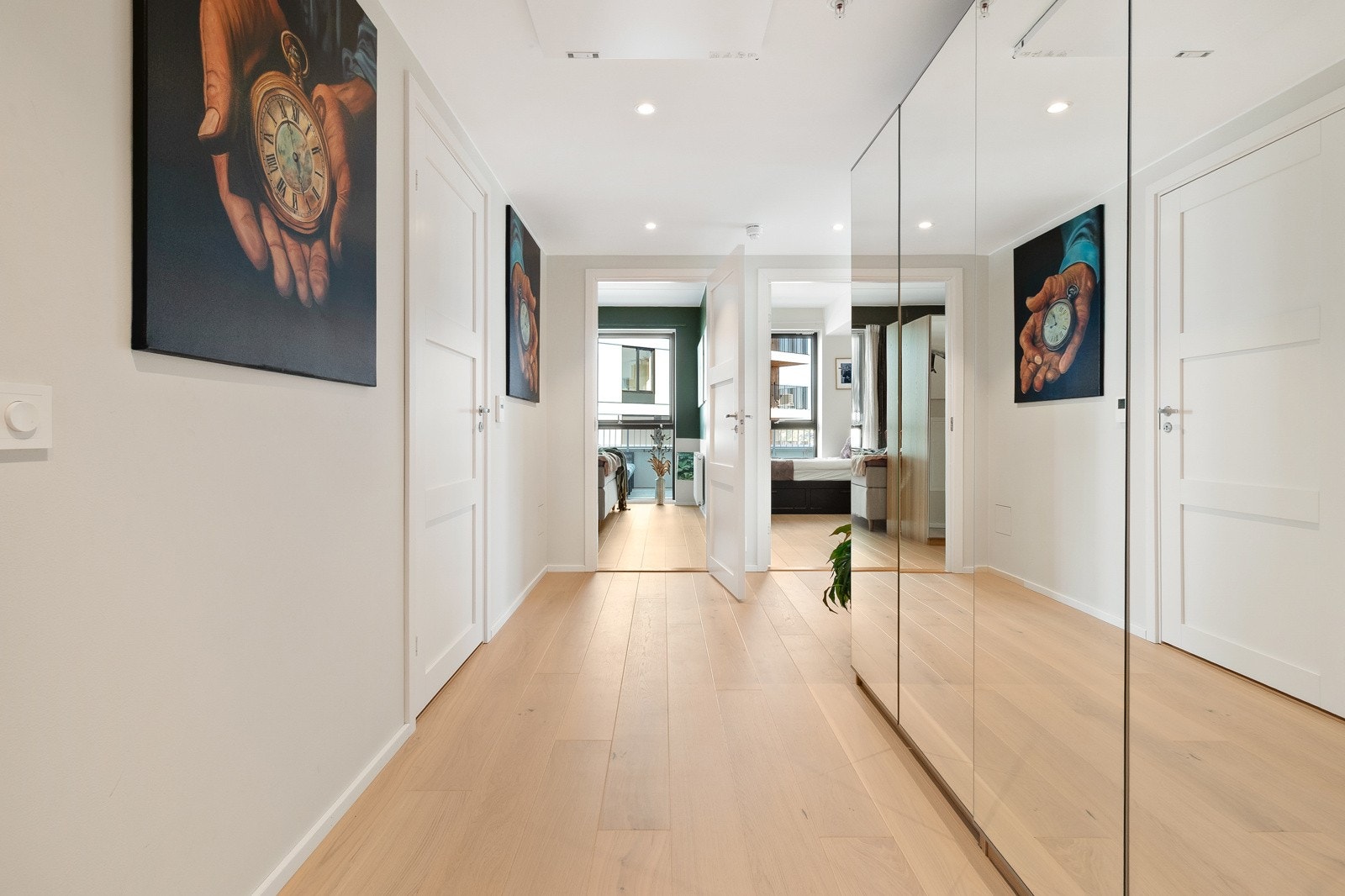 Hvite vegger og enstavsparkett gir et helhetlig preg i leiligheten. Her har du plass til stor garderobe for oppbevaring. Galleribilde