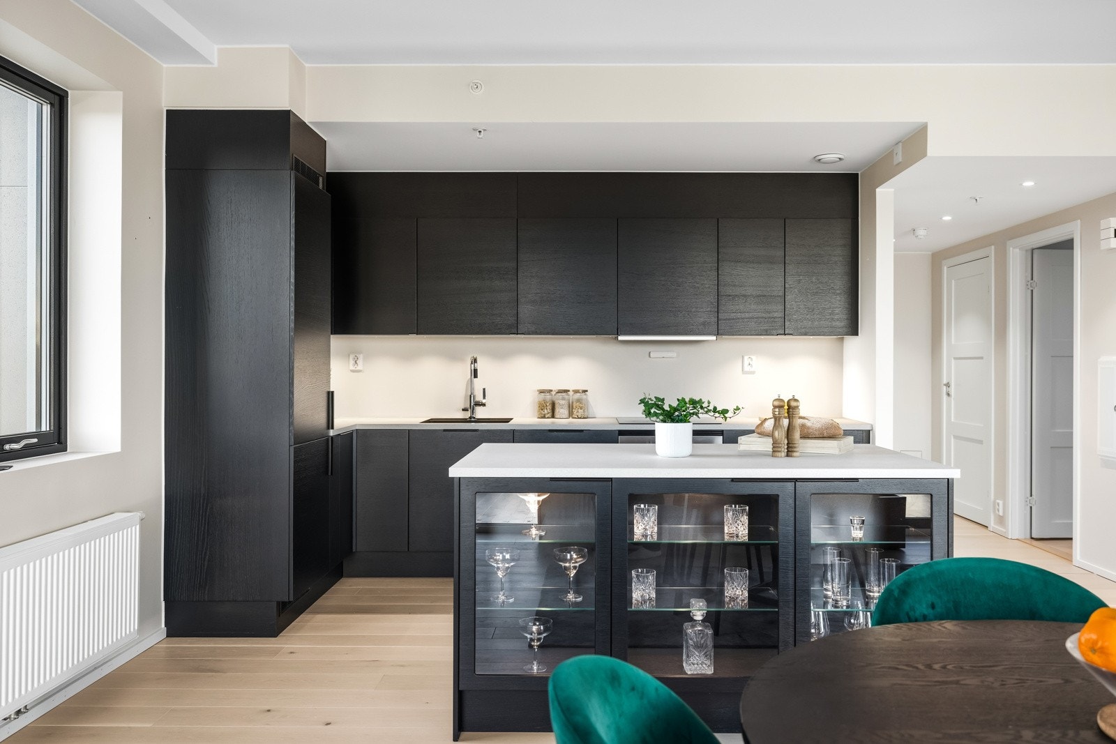 Leiligheten byr på et stilrent HTH-kjøkken med glatte fronter, rikelig skapplass og en praktisk kjøkkenøy med integrert belysning som virkelig er et blikkfang. Galleribilde