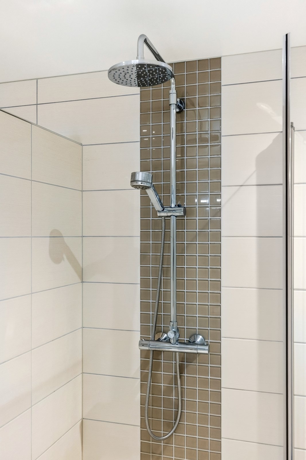 Dusjsonen har en moderne regnfallsdusj og praktiske, innfellbare glassdører. Galleribilde