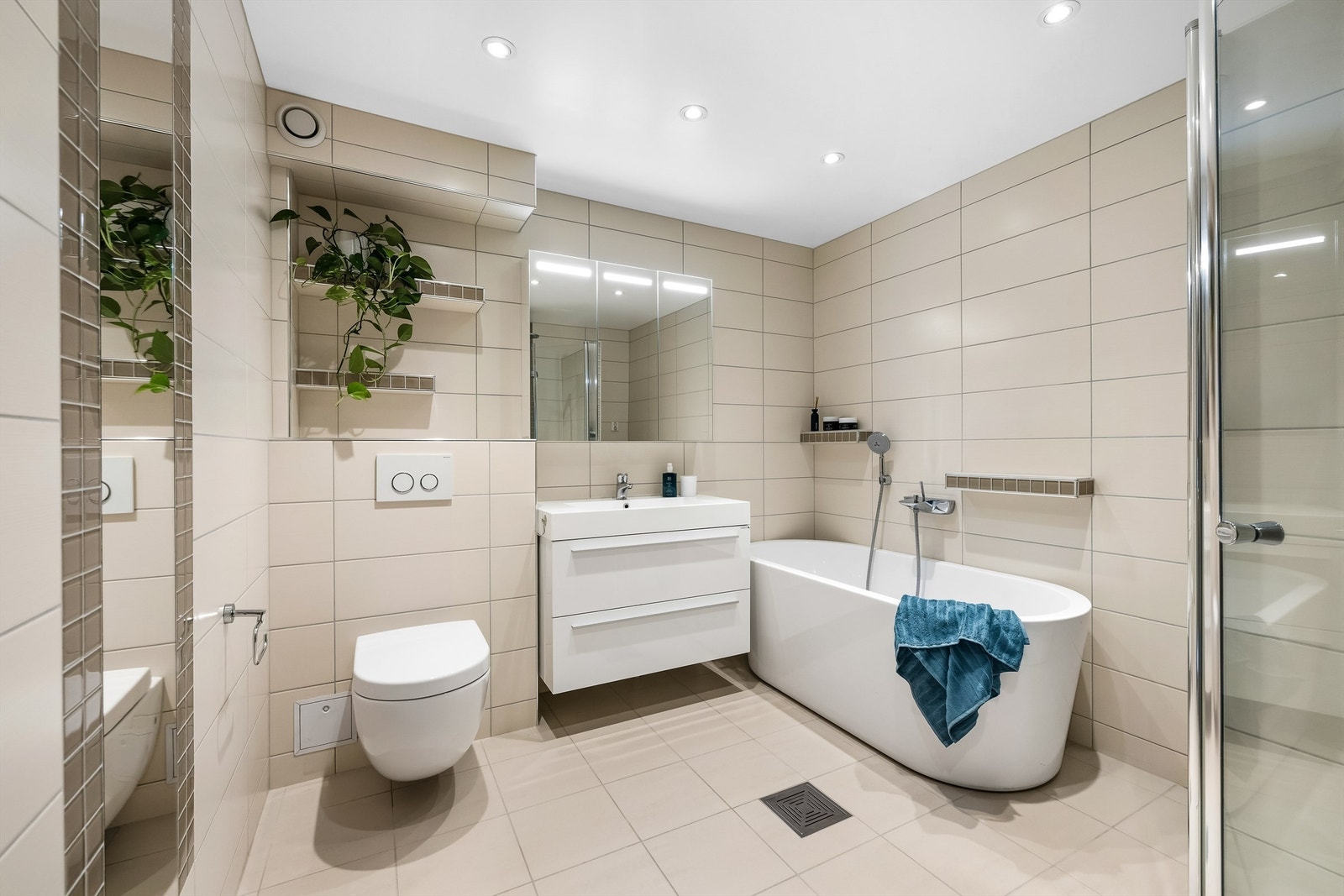 Stort, flislagt bad utstyrt med både badekar og separat dusjhjørne. Galleribilde