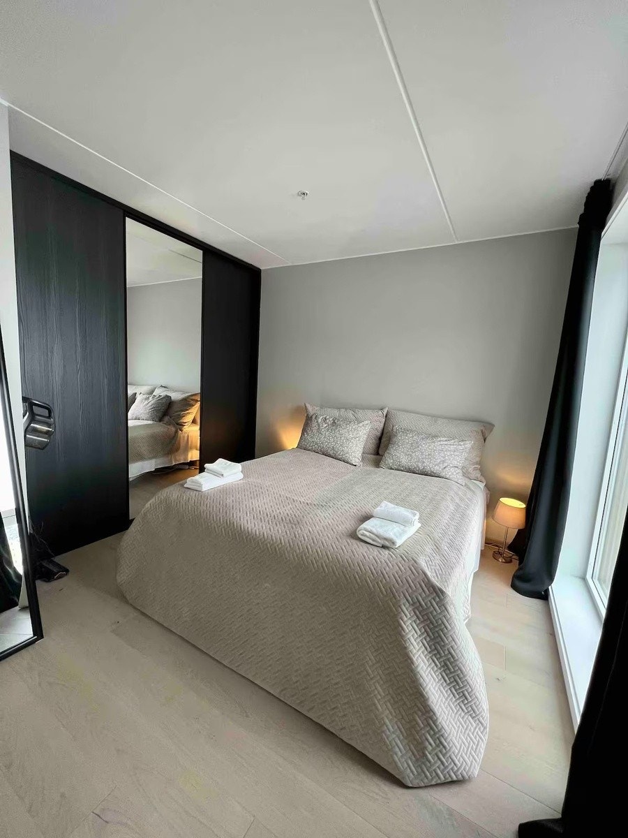 Hovedsoverom og godt med skapplass. Vinduer fra gulv til tak på høyresiden med helt lystette gardiner Galleribilde