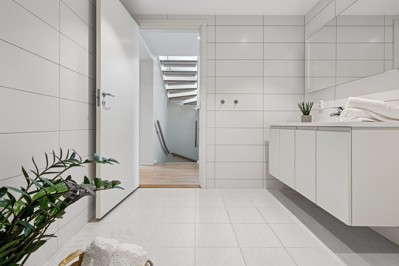 Badet er utstyrt med en dusjnisje med innfellbare glassdører, vegghengt toalett og en praktisk servantinnredning. Galleribilde