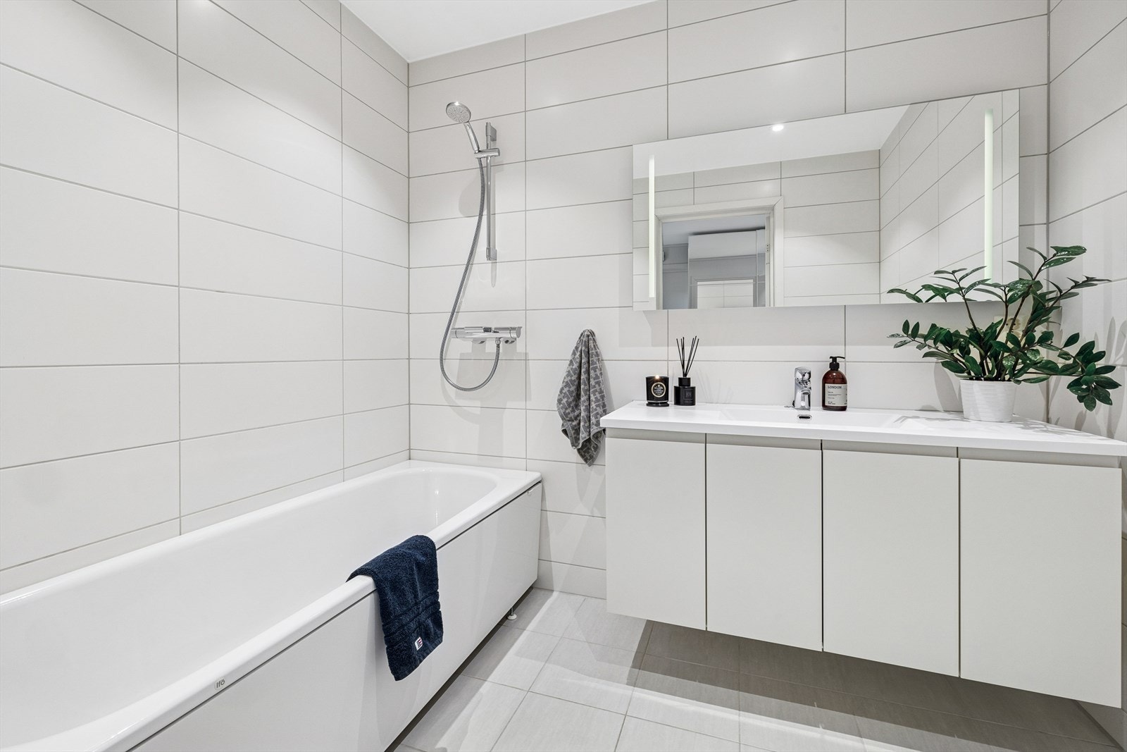 Eiendommen har to bad, ett i første etasje og ett i andre etasje. Badet er pent flislagt med varmekabler i gulvet, vegghengt toalett, badekar og servantinnredning, samt downlights i himlingen. Galleribilde