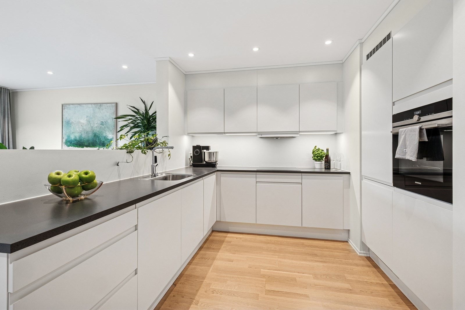 Elegant kjøkkeninnredning fra HTH, komplett med hvitevarer som komfyr, induksjonstopp, oppvaskmaskin og en kombinert kjøleskap/fryser. Dette kjøkkenet kombinerer stil og funksjonalitet, og gir et moderne preg. Galleribilde