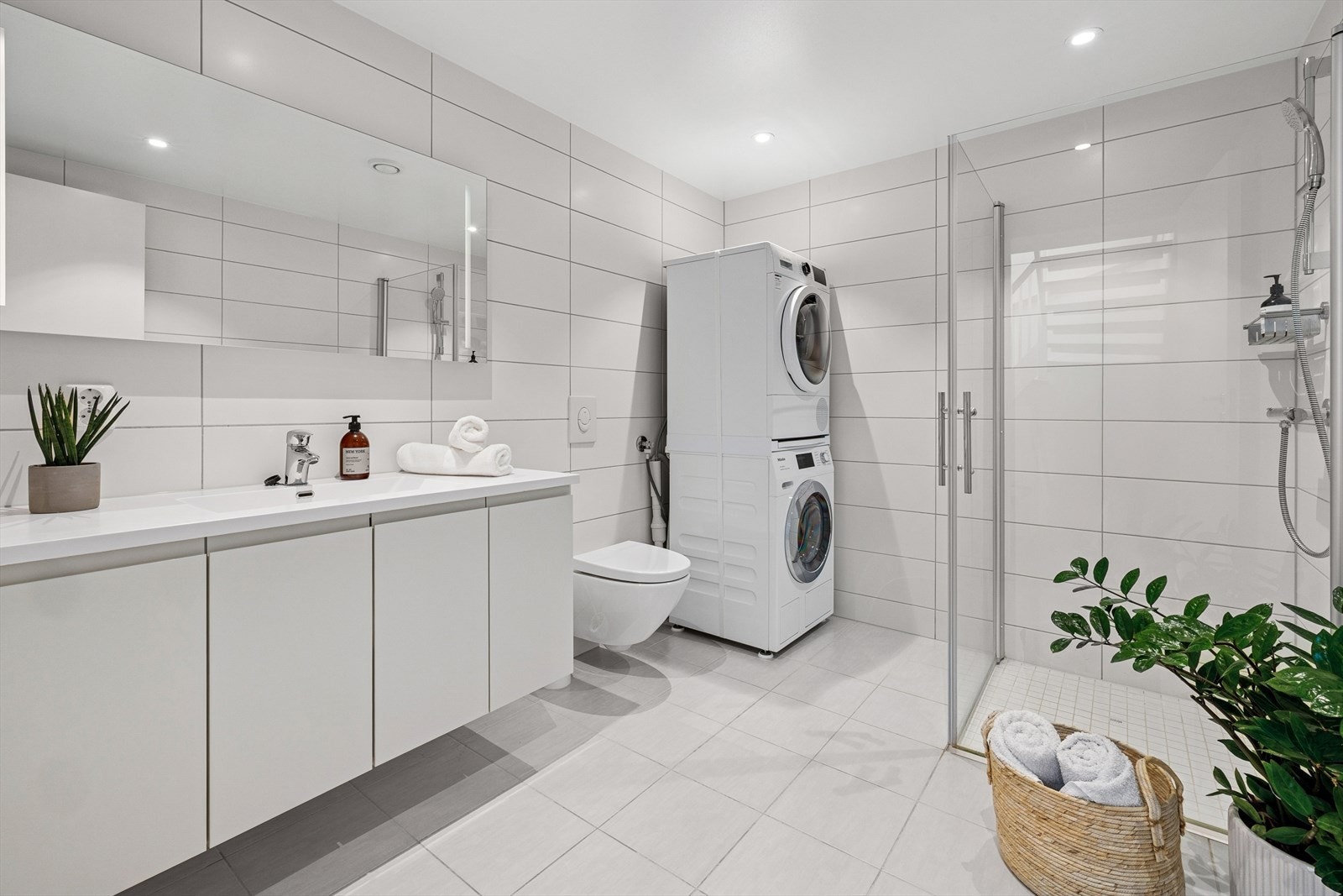 Andre etasje har et stilfullt, flislagt baderom med varmekabler i gulvet, downlights i taket og belysning i speilet. Galleribilde