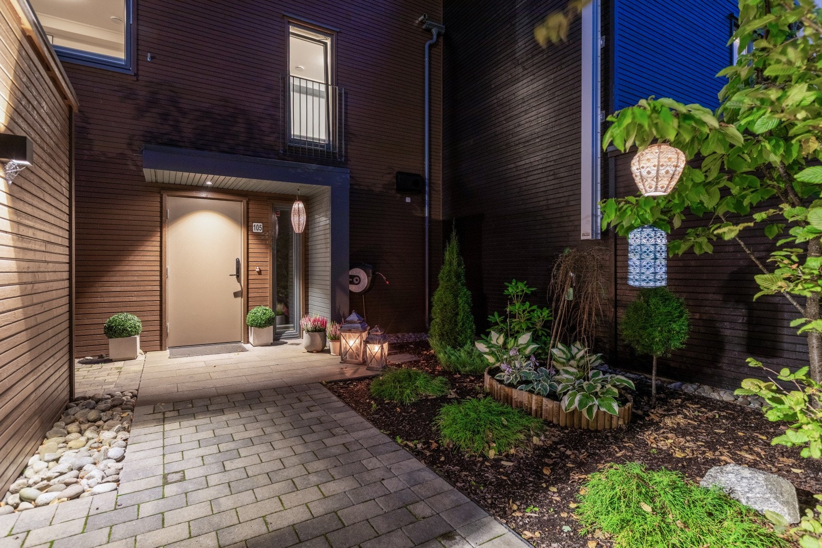 Inngangspartiet er pent opparbeidet med både beplantning og belegningsstein. Galleribilde