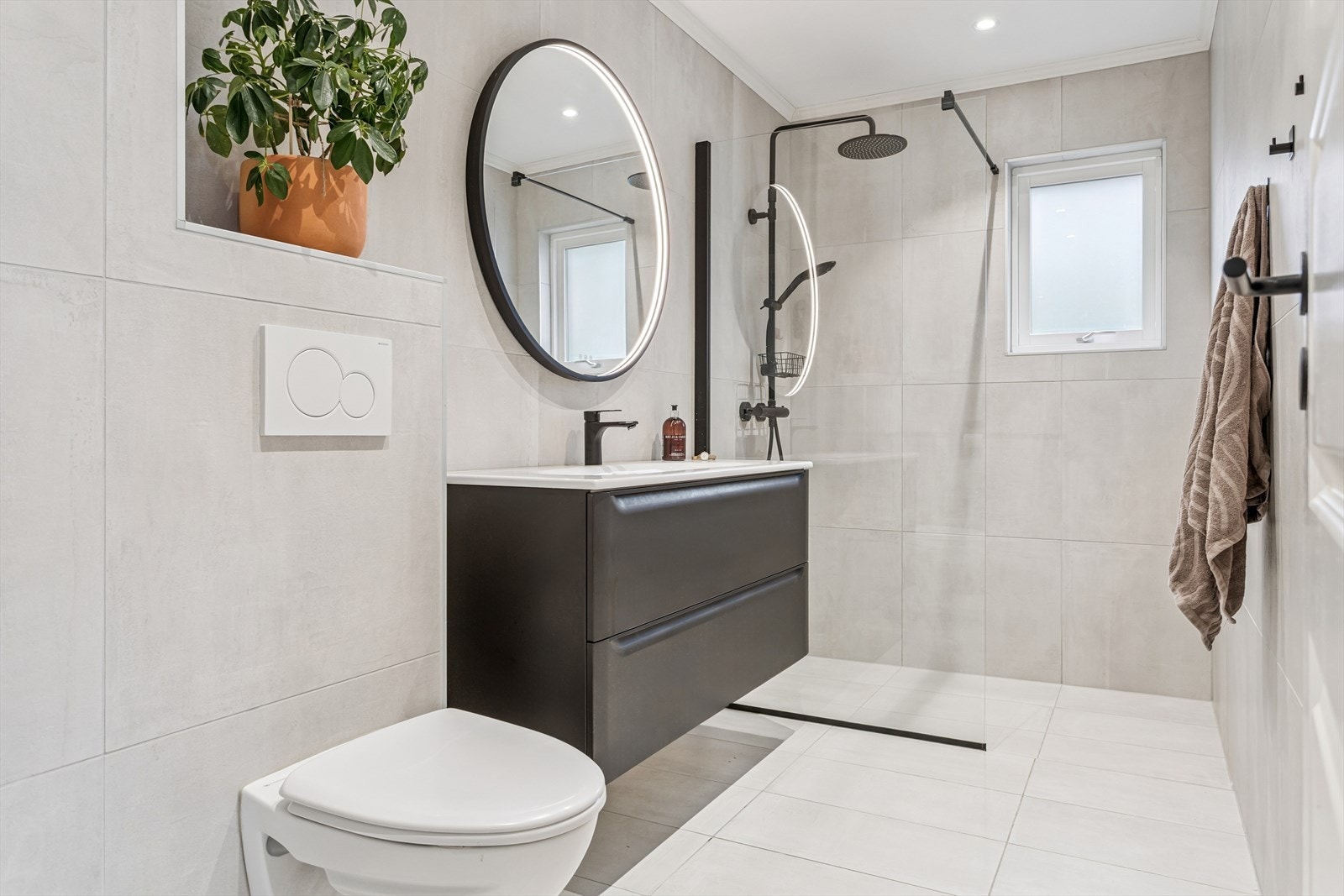 Et lekkert og funksjonelt baderom, renovert i 2021. Her er alle overflater flislagt, og dusjsonen er elegant adskilt med glassvegg. Varme i gulv. Galleribilde