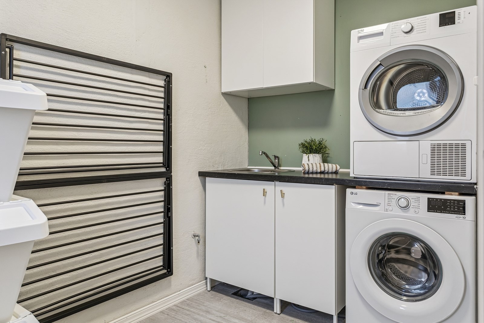 Meget praktisk med eget vaskerom. Flislagt gulv med varme, og malte vegger. Innredet med skap, benkeplate og utslagsvask i stål. Opplegg for vaskemaskin. Galleribilde