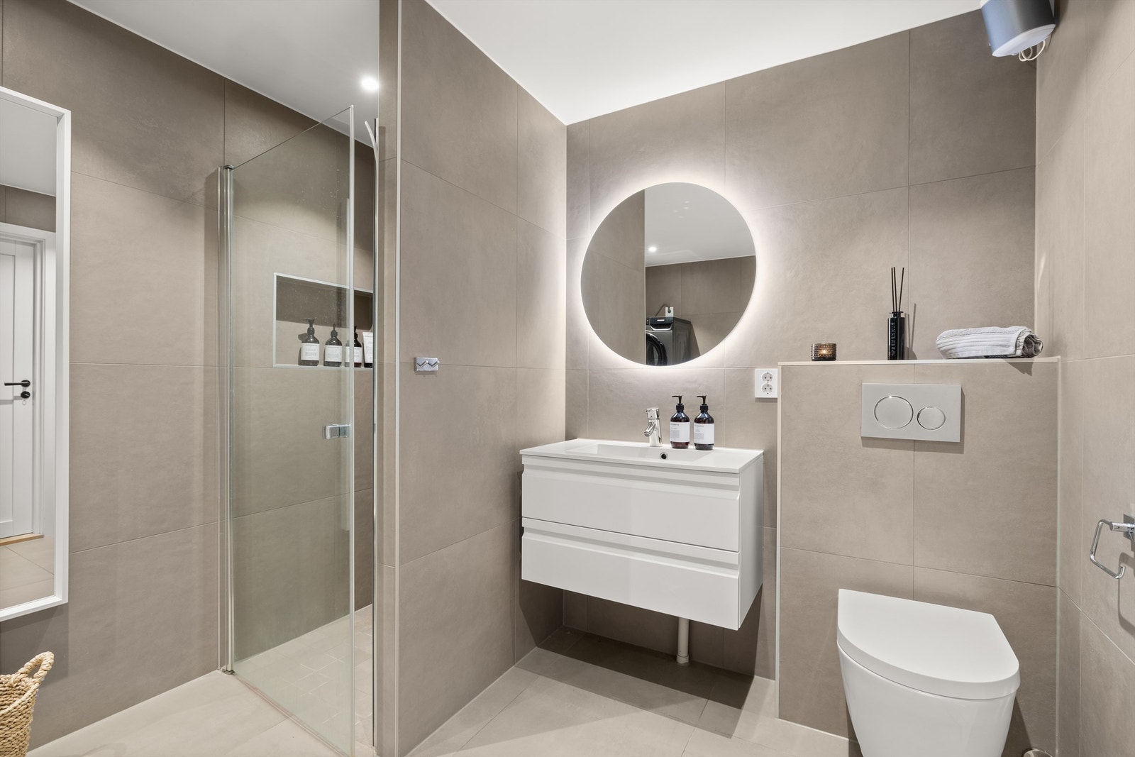 Badet er utstyrt med dusjnisje, vegghengt toalett fra Geberit og servant med belysning. Galleribilde