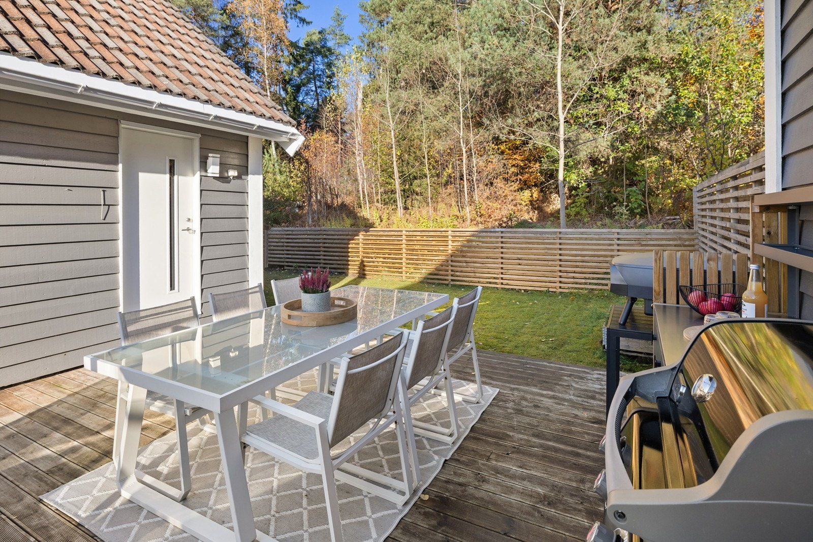 En del av terrassen går over i en platting med direkte tilgang til hagen. Galleribilde