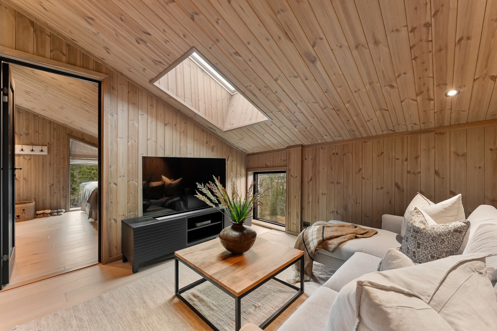 Ved soverommene i loftsetasjen er det en luftig stue med plass til sofa og tv-møblement - et kjærkomment element for barnefamilier eller litt ekstra privatliv for tilreisende feriegjester. Galleribilde