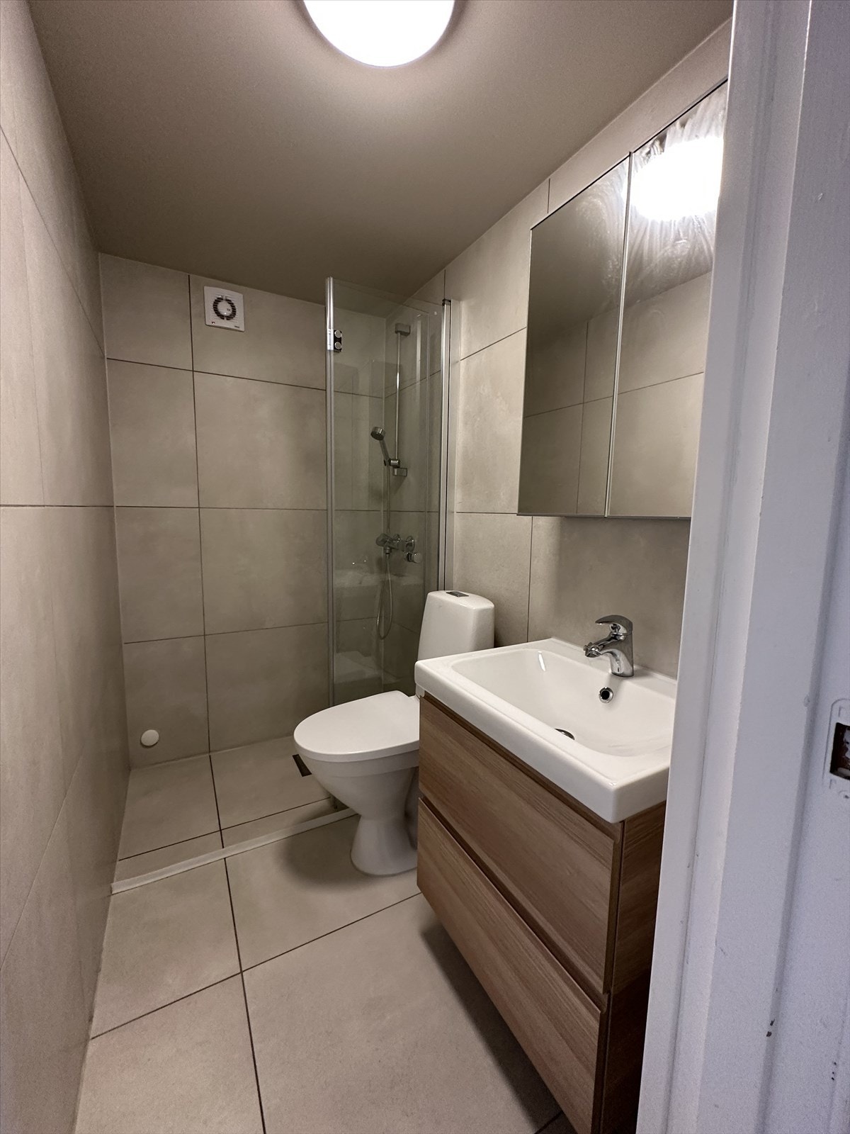 Hybel: Flislagt baderom fra 2021 m3d servant med underskap og speilskap på vegg, klosett og dusj med glassvegg. Galleribilde