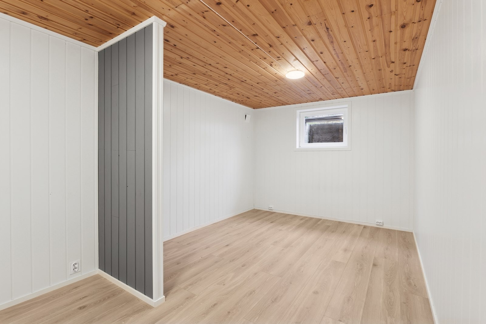 Lyst og romslig rom i underetasjen - perfekt som gjesterom, hjemmekontor eller hobbyrom. Lyse vegger, trepanel i taket og laminatgulv. Galleribilde
