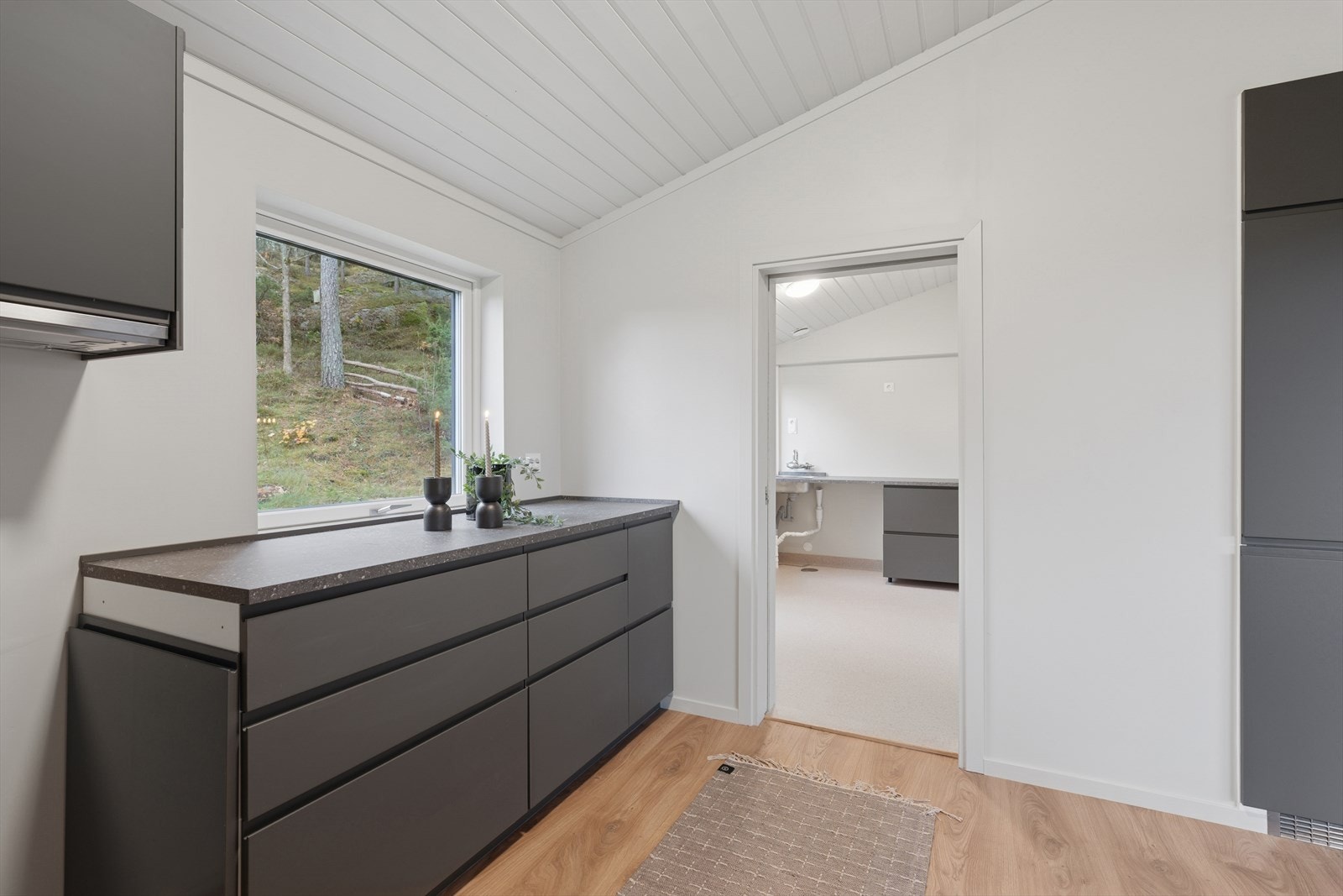 Moderne kjøkken med praktisk tilgang til vaskerom - en funksjonell løsning for hverdagen. Galleribilde